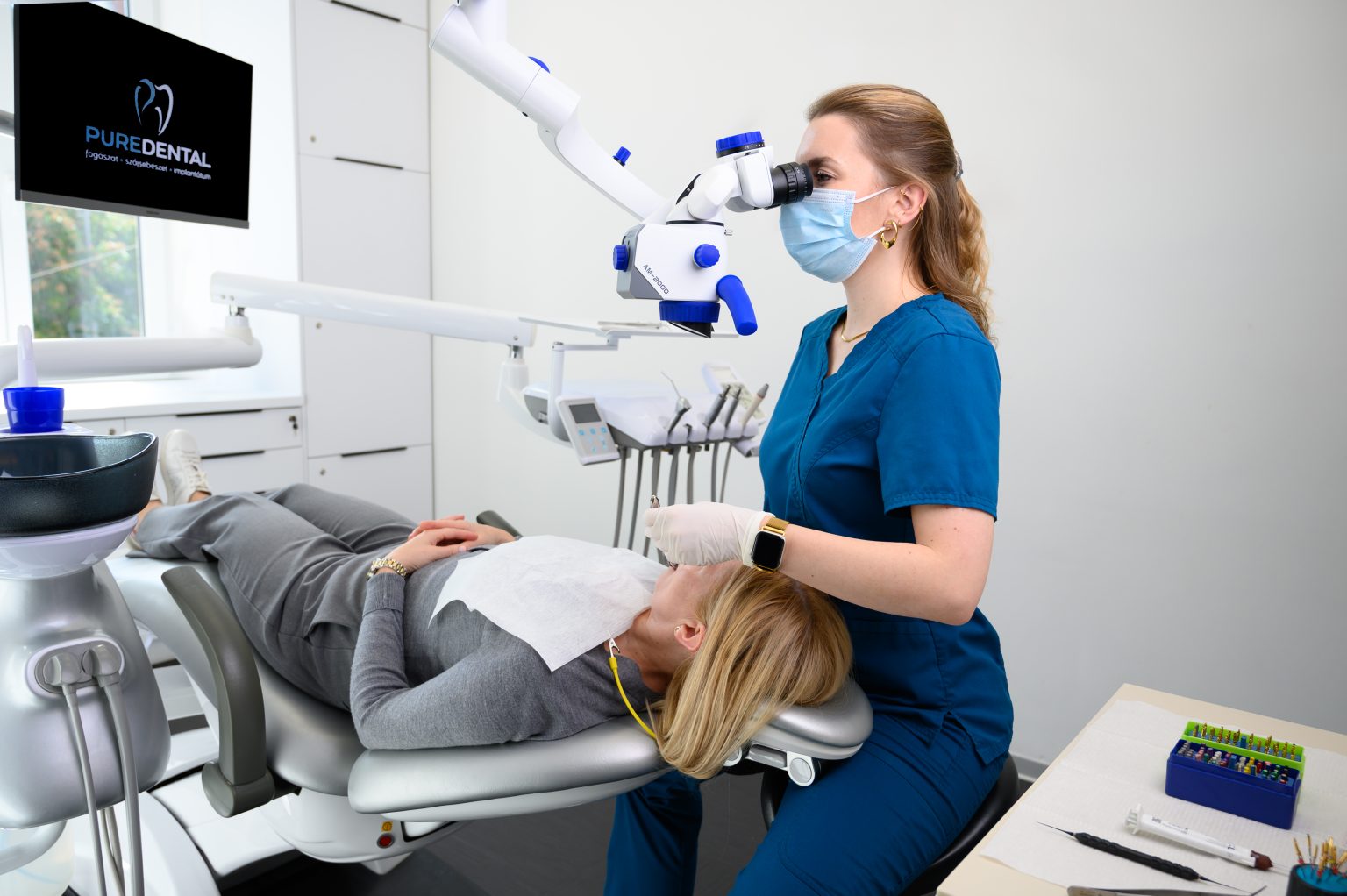 Fogorvos mikroszkóp alatt kezeli a páciens fogát a PureDental budapesti rendelőjében